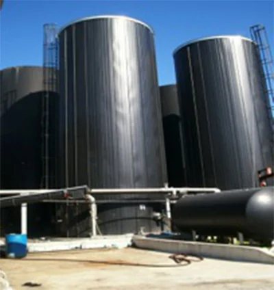 Black storage tanks and piping at the plant