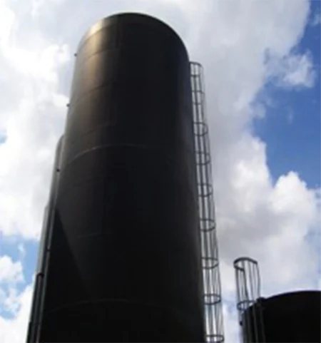 A tall black storage tank with a caged ladder